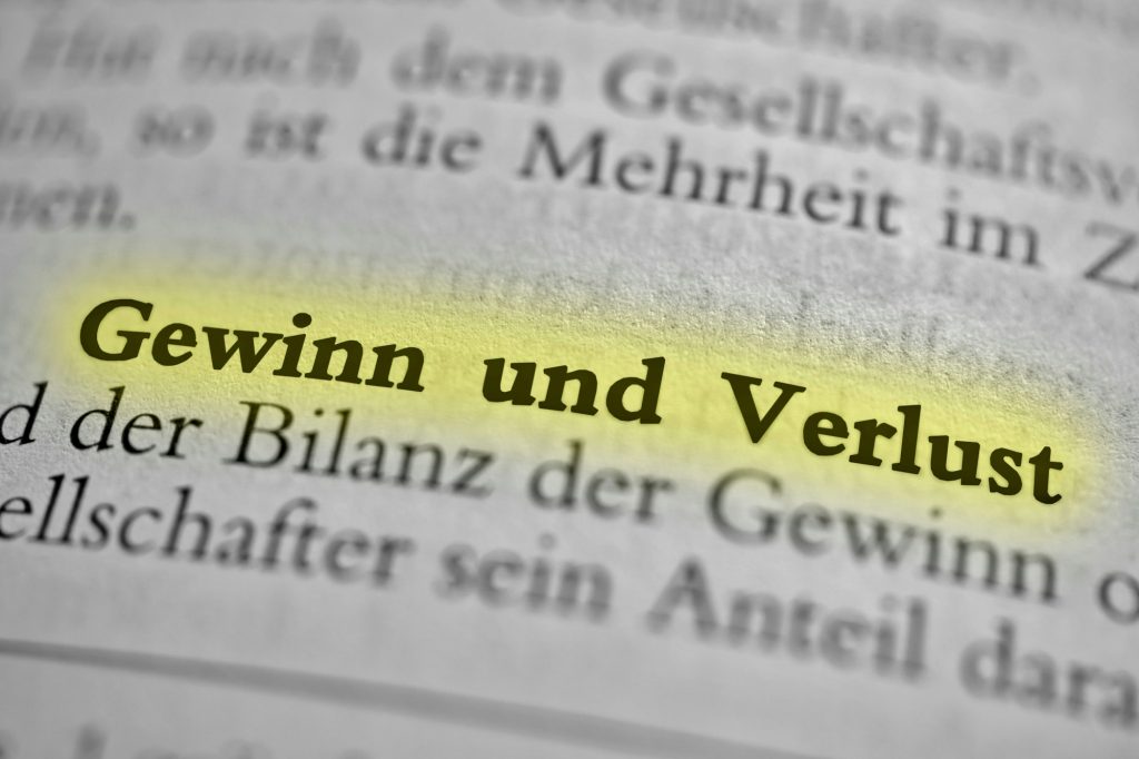 Closeup of german words Gewinn und Verlust written in bold font and highlighted with a yellow marker